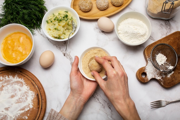 Handen die voedselkroketten van dichtbij maken