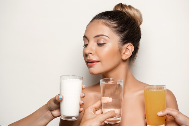 Handen die water, sap of melk aanbieden aan mooie vrouw