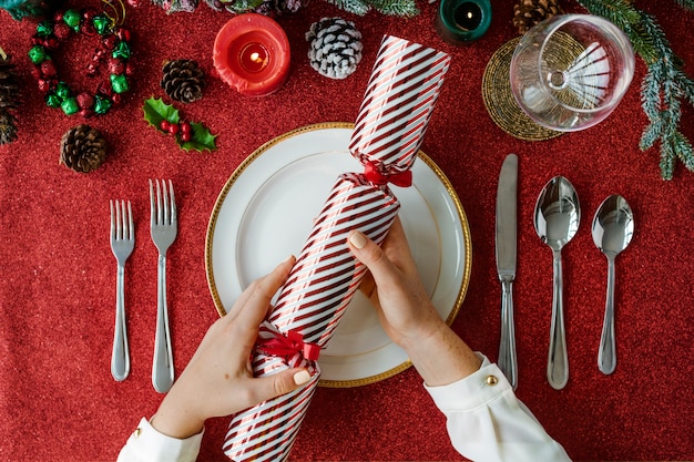 Handen met cadeau op kerstvakantie viering op rode tafel