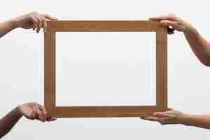 Gratis foto handen met groot houten frame