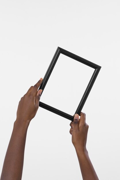 Handen met leeg donker frame
