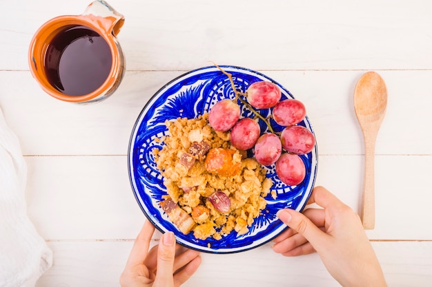 Gratis foto handen met plaat met voedsel op tafel