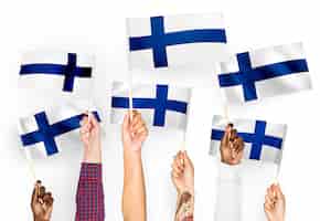 Gratis foto handen met vlaggen van finland zwaaien