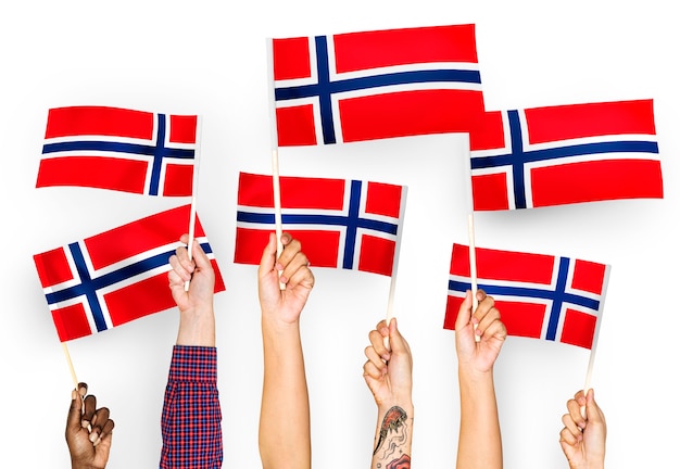 Handen met vlaggen van noorwegen zwaaien