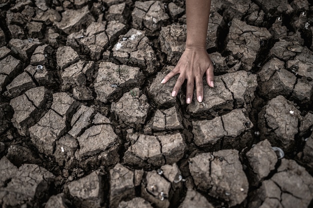 Handen op droge grond, broeikaseffect en watercrisis