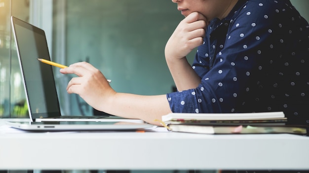 Handen van een man die met laptop werkt