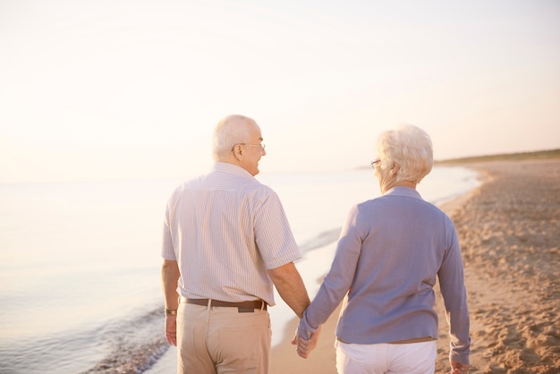 Handen vasthouden tijdens het wandelen op het strand