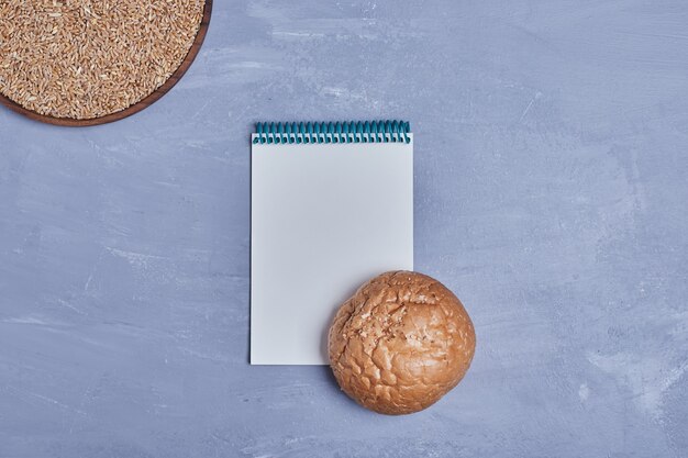 Handgemaakt rond brood met een receptenboek opzij.