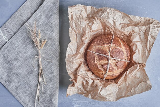 Handgemaakt rond broodje op een stuk papier.