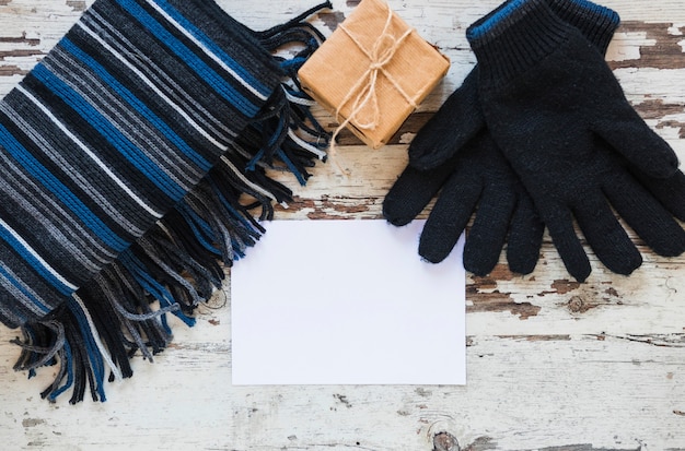 Handschoenen en sjaal dichtbij gift en document blad