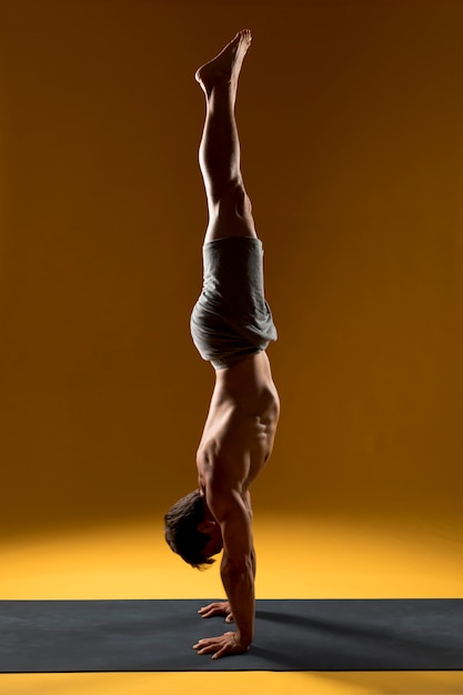 Gratis foto handstand yoga pose op mat