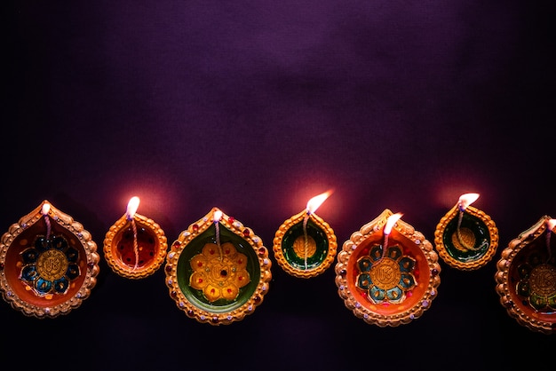 Gratis foto happy diwali - mooie diwali-diya's 's nachts met bloemen