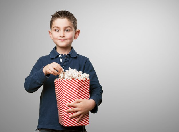 Happy jongen het eten van popcorn