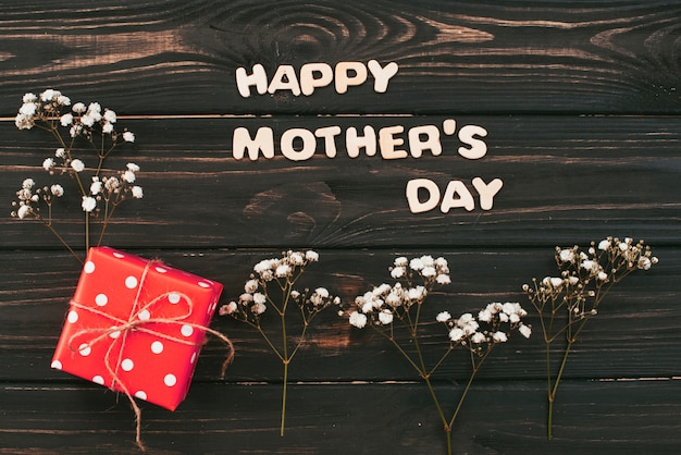 Gratis foto happy mothers day inscriptie met geschenkdoos en bloem takken