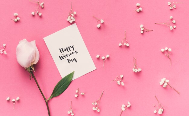 Happy Womens Day inscriptie op papier met roze bloem