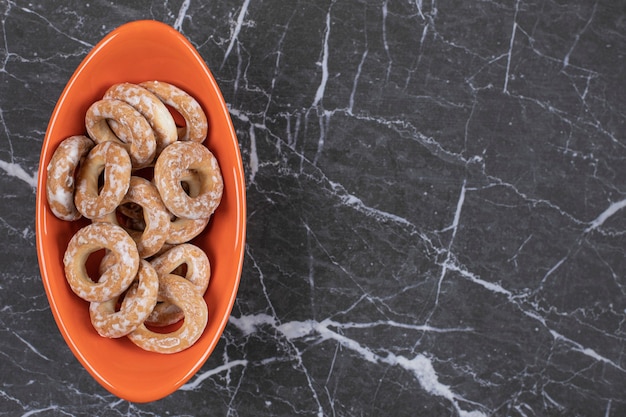 Gratis foto harde gezouten pretzels in oranje kom.