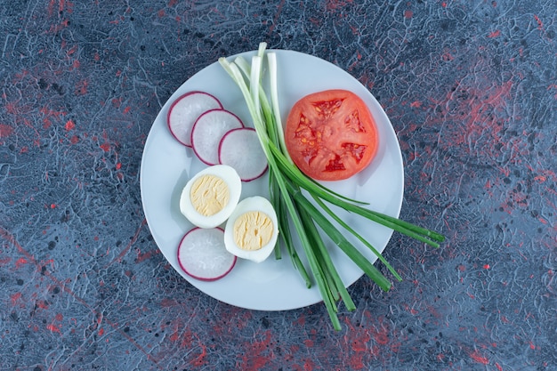 Hardgekookt ei met gesneden tomaat en radijs