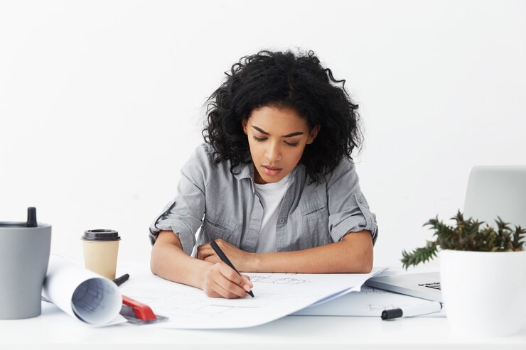 Gratis Foto hardwerkende geconcentreerde vrouwenarchitect die een grijs losgeknoopt overhemd draagt