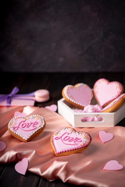 Hartvormige Valentijnsdag koekjes op satijn met kopie ruimte