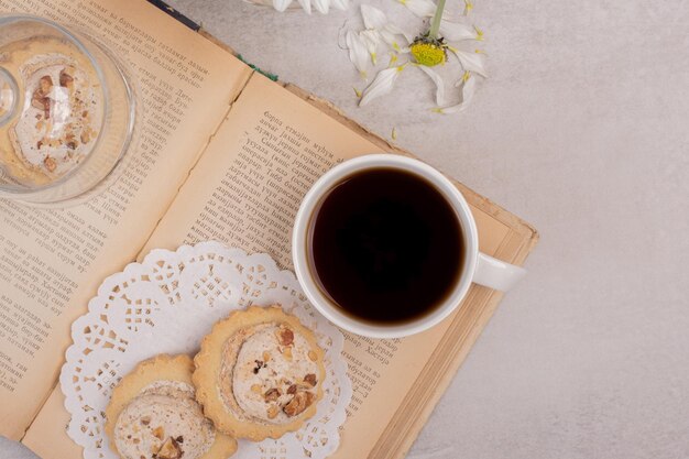 Havermoutkoekjes en kopje thee op open boek.