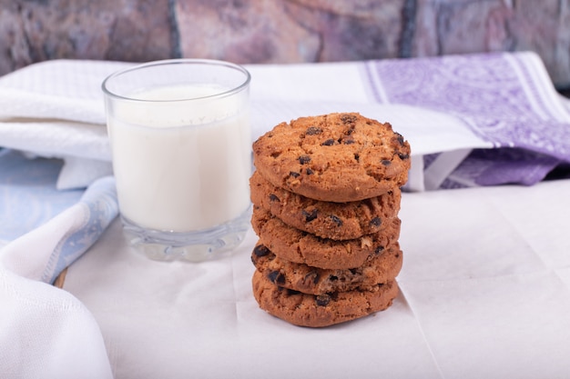 Havermoutkoekjes met een glas melk op wit tafelkleed