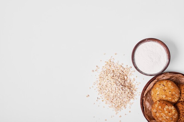 Havermoutkoekjes met ingrediënten op wit.