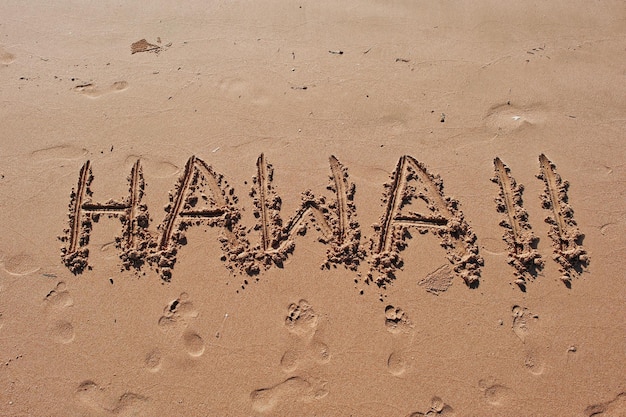 Gratis foto hawaii geschreven in het zand op het strand