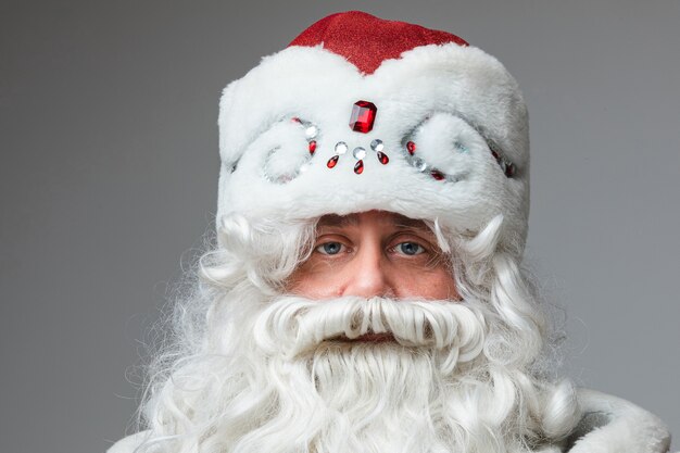 Headshot van de kerstman in rode hoed, grijze bebaarde vermoeide man