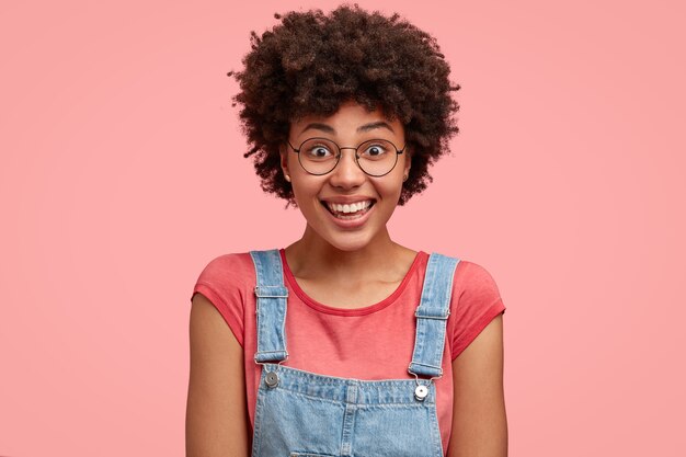 Headshot van gelukkige Afro-Amerikaanse vrouw draagt t-shirt en denim tuinbroek