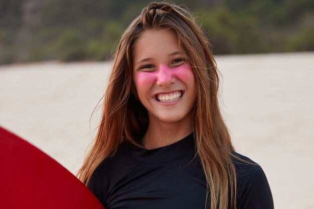 Headshot van vrolijke jonge toeristen leren surfen, poseert tegen de kust