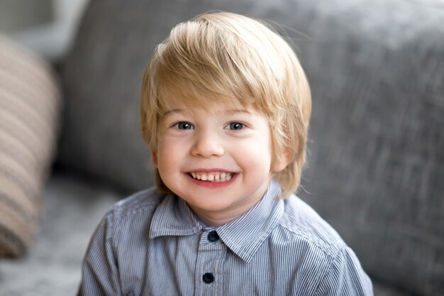 Headshotportret van leuke glimlachende jong geitjejongen die camera bekijken