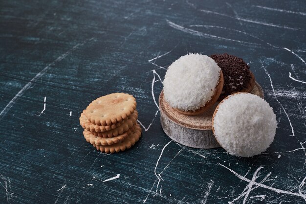 Heemstkoekjes met chocolade en kokospoeder op een stuk hout.