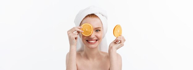 Heerlijk eten voor een gezonde levensstijl mooie jonge shirtless vrouw met stuk sinaasappel staande