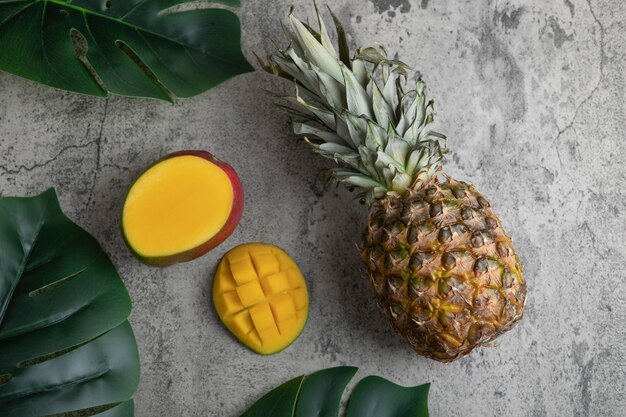 Heerlijk exotisch mangofruit en ananas op marmeren oppervlak.