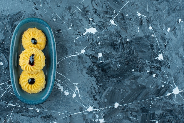 Heerlijk koekje op een bord, op de blauwe tafel.