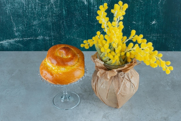 Heerlijk zoet gebak en gele bloemen op marmer.