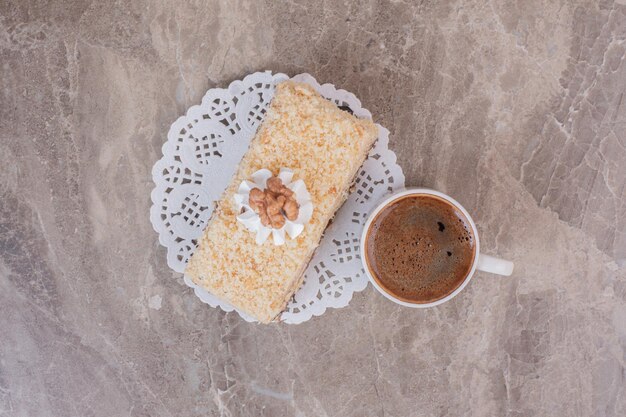 Heerlijke cake en kopje koffie op marmeren oppervlak.