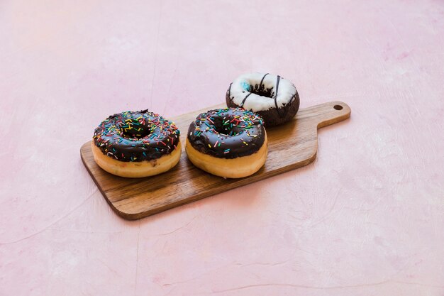 Heerlijke chocolade donuts op houten hakbord