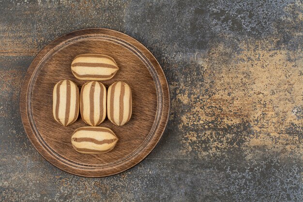 Heerlijke chocolade gestreepte koekjes op houten plaat.