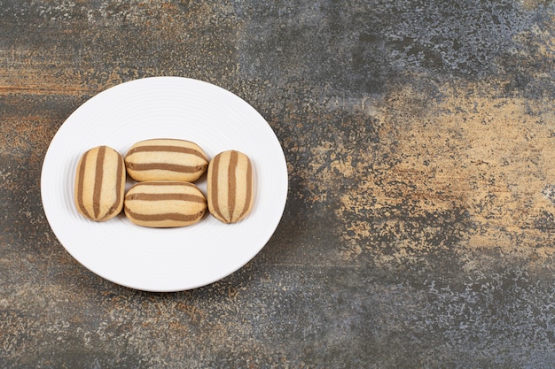 Gratis foto heerlijke chocolade gestreepte koekjes op witte plaat.