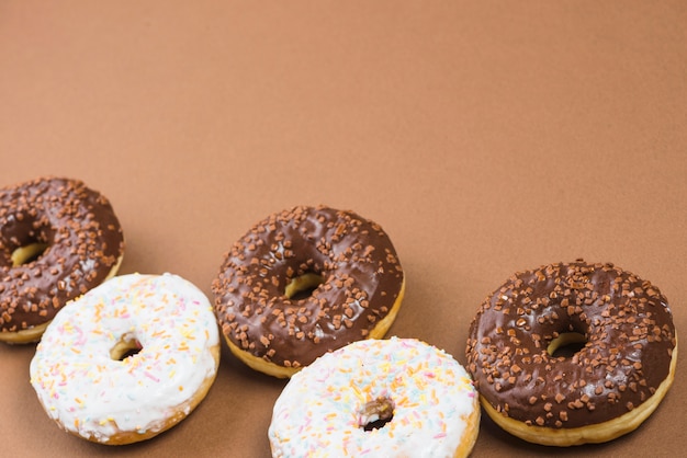 Heerlijke donuts met suikerglazuur op bruine achtergrond