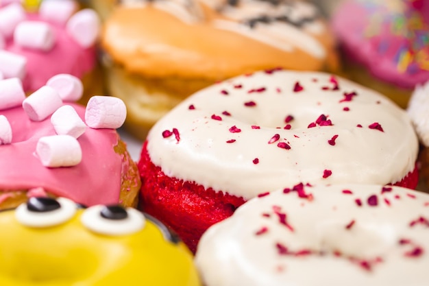Gratis foto heerlijke donuts van verschillende smaken op papier close-up