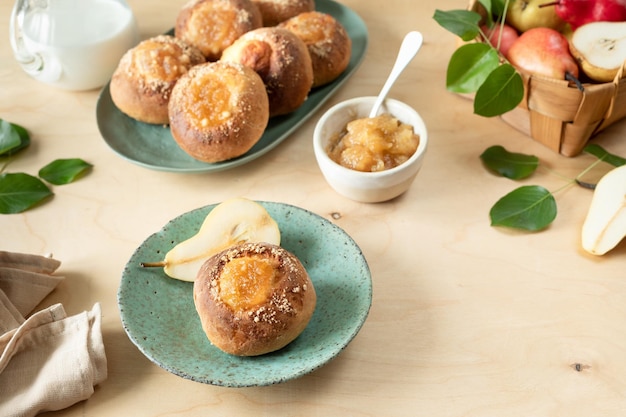 Heerlijke huisgemaakte broodjes met jam en verse peren op een houten ondergrond Minitaartjes Kookrecept