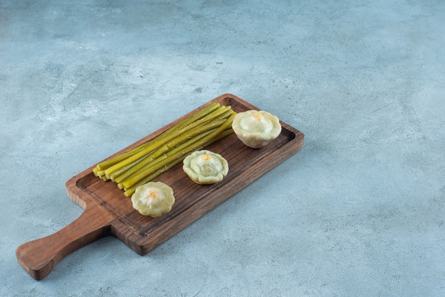 Heerlijke ingemaakte minipompoen en stokjes op een bord, op de marmeren tafel.