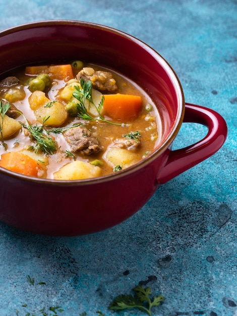 Gratis foto heerlijke kikkererwten-aardappelcurry met rundvlees in een rode pan