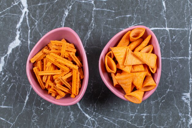 Heerlijke knapperige stick en triangelchips in roze kommen.