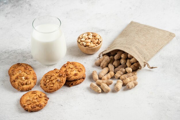 Heerlijke koekjes met honing, melk en pinda's op marmeren tafel.