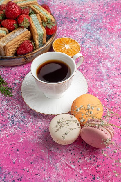 Heerlijke koekjes sandwiches met aardbeien en macarons en koffiekopje