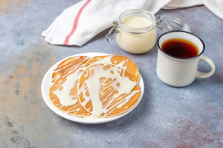 Gratis Foto heerlijke pannenkoeken met gecondenseerde melk.