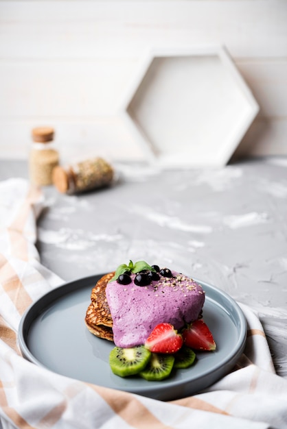 Heerlijke pannenkoeken met helften van aardbei en kiwi hoge weergave